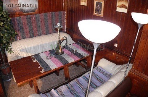 Комната отдыха с мягкими диванами и деревянной отделкой в бане Русские парные
